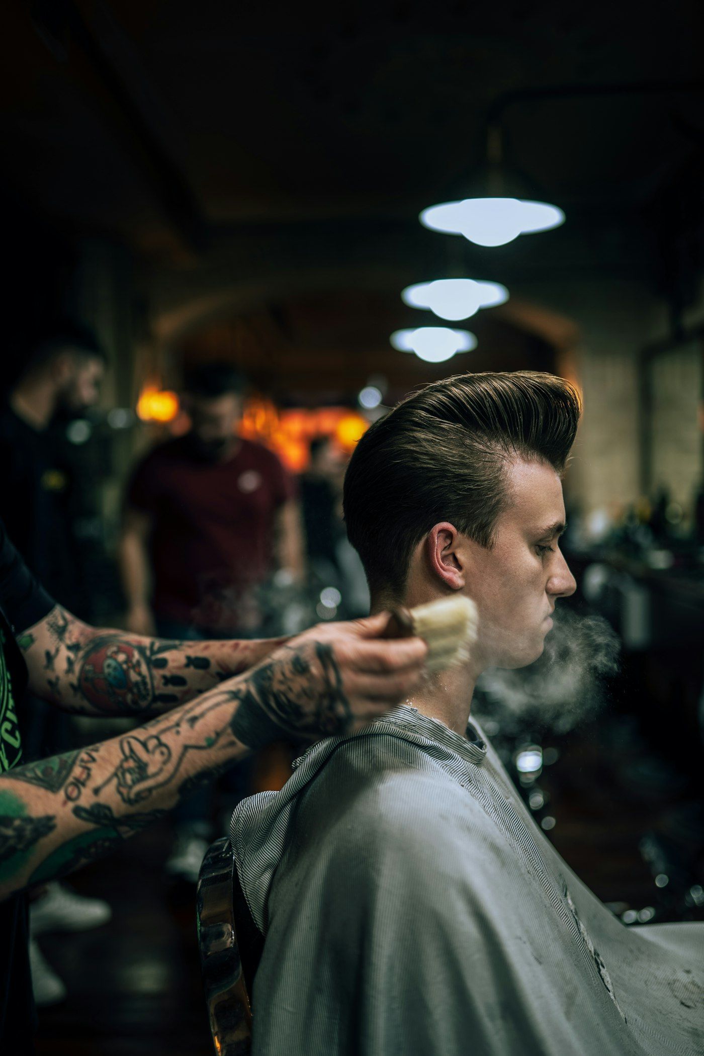 Barber oprašuje klientovi krk po střihu